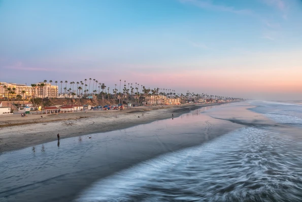 View of the Oceanside, CA beach from the pier at sunset.