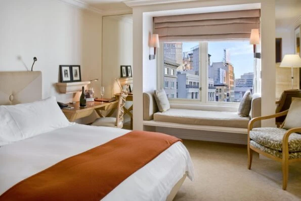 Deluxe king room interior with neutral colors and hints of orange in the bedroom.