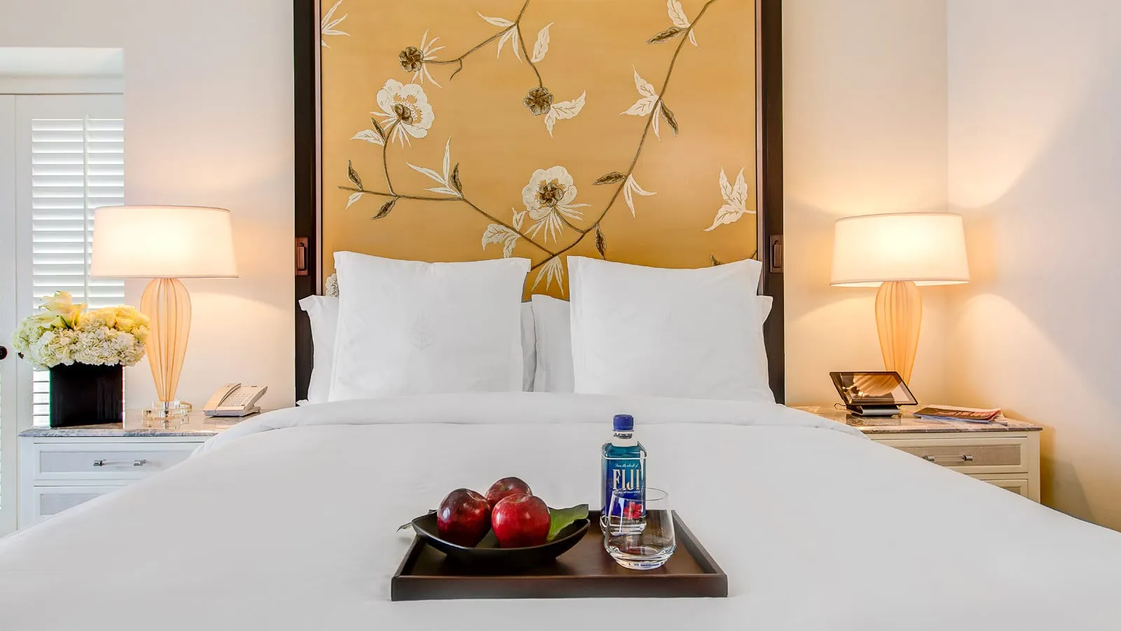 Beige floral headboard above a bed with crisp white sheets.