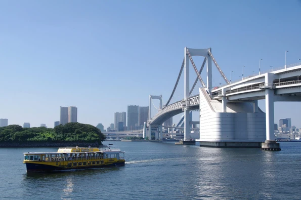 A tour boat on the water near the Rainbow Bridge to Odaiba island.