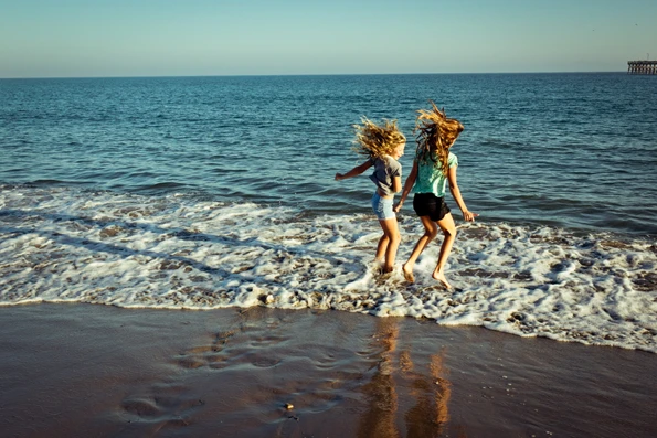 two girls playing at the water's edge at the beach in Santa Barbara