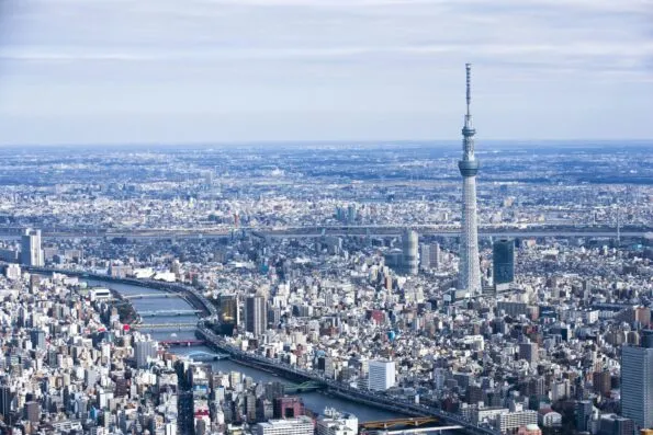 Tokyo Skytree rising above the city near the river. A panoramic view.