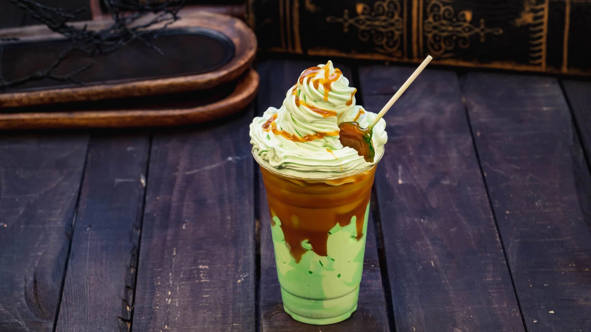 Green smoothie with green whipped cream and caramel dripping.