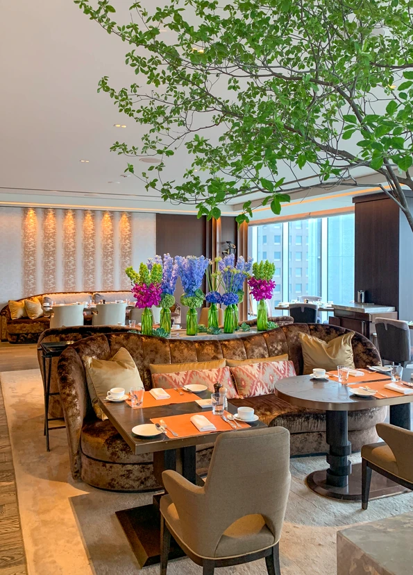 Plush seating, hydrangea flower arrangements and tree inside Motif in the early morning.