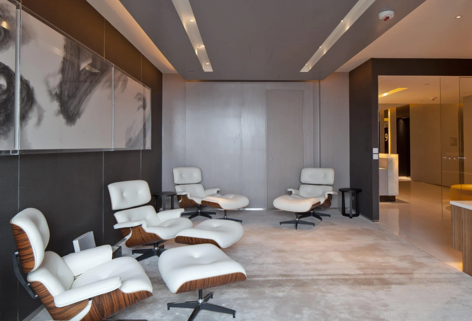 Ergonomic chairs and ottomans in the simple Timeless Lounge for guests to relax in.