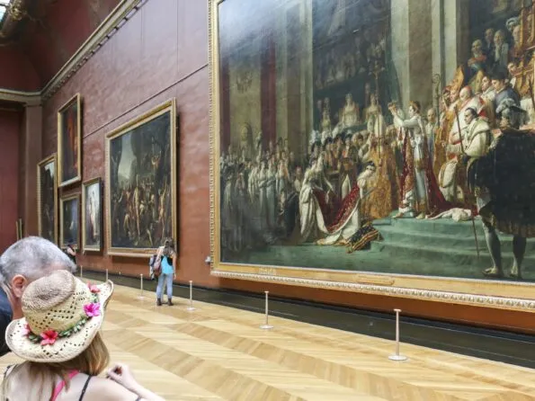 My husband explaining to my daughter the significance of The Coronation of Napoleon by Jacques-Louis David in front of the massive painting.