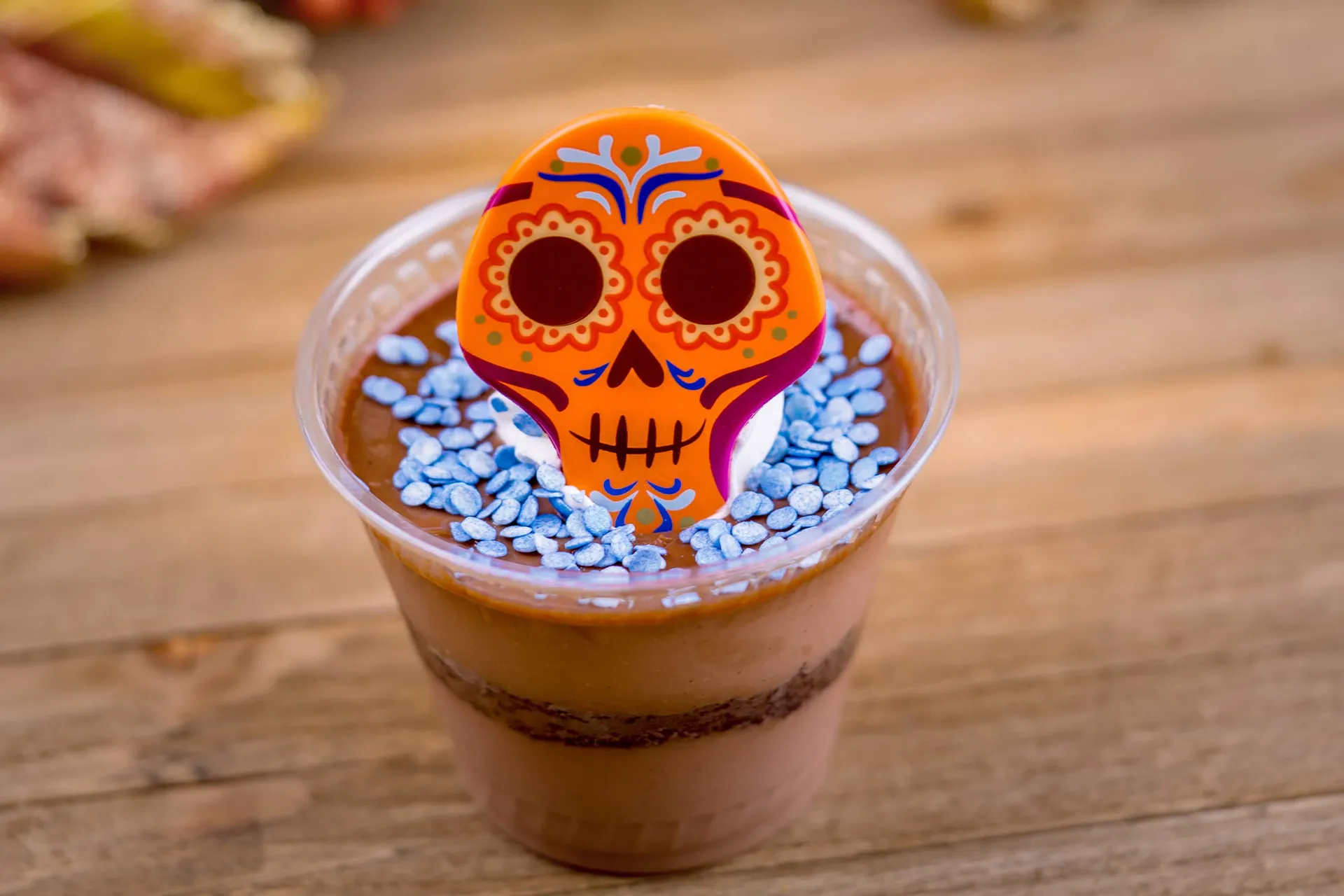 An orange candy skull rests on top of the pot de creme.