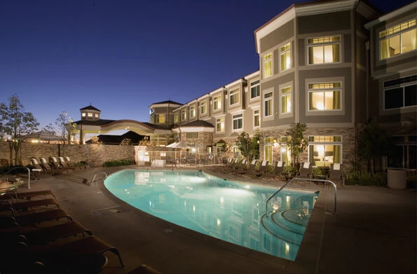 The pool deck lit up at night at West Inn and Suites boutique hotel in Carlsbad