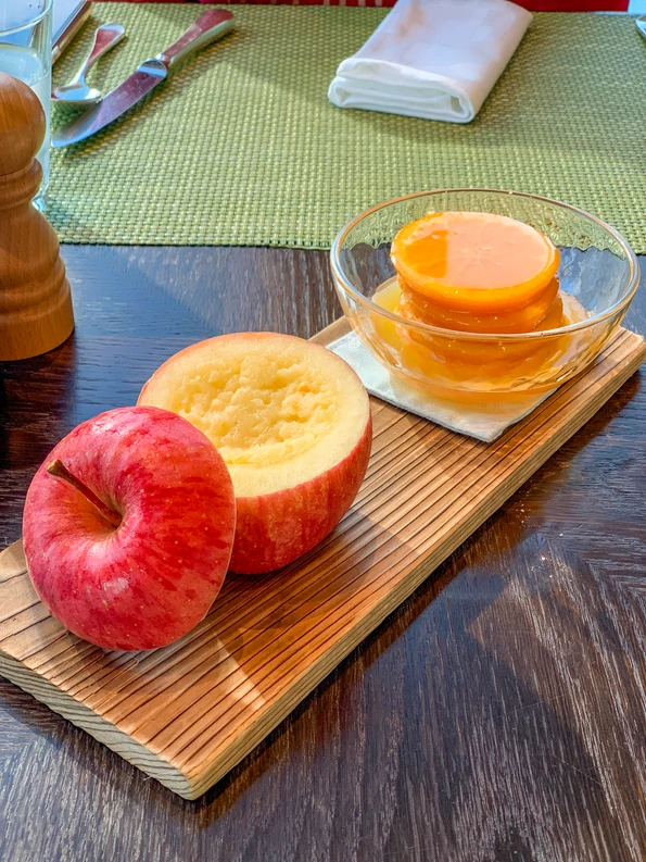 Complimentary apple compote and sweet oranges on a wood plank are given to guests at breakfast at Four Seasons Hotel Tokyo at Marunouchi.
