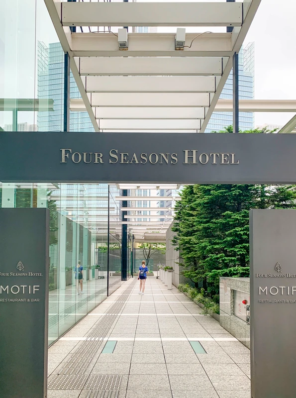 The street entrance to Four Seasons Hotel Tokyo at Marunouchi with a hotel sign.