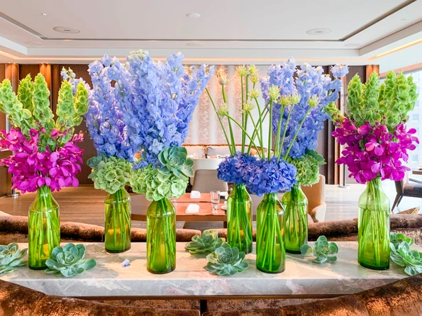 Colorful flowers and succulents in green vases at Motif restaurant inside Four Seasons Tokyo