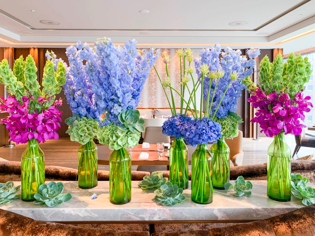 Colorful flowers and succulents in green vases at Motif restaurant inside Four Seasons Tokyo
