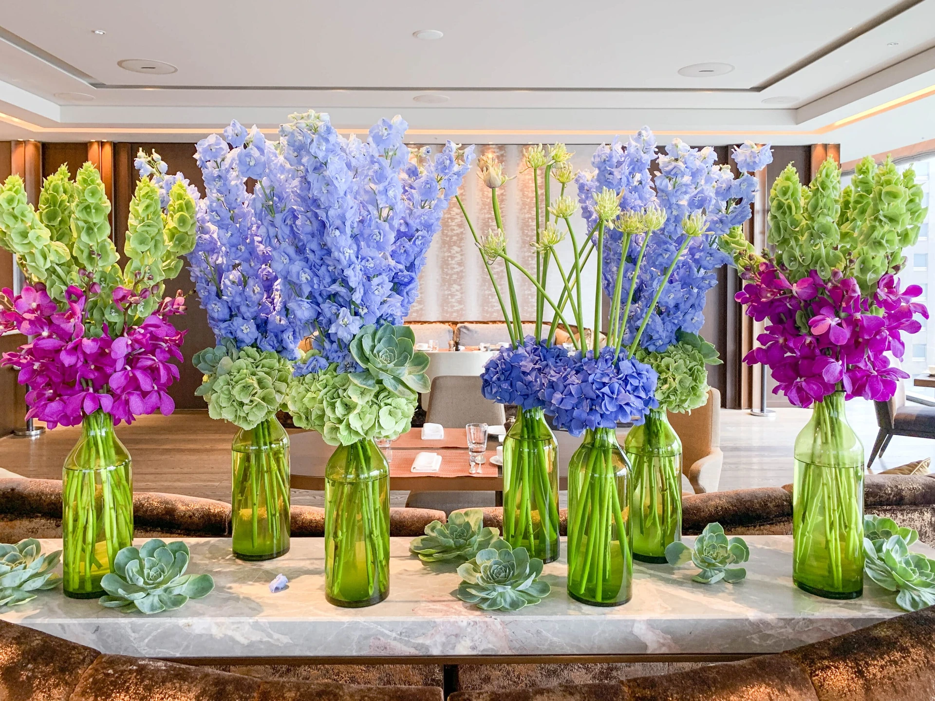 Colorful flowers and succulents in green vases at Motif restaurant inside Four Seasons Tokyo