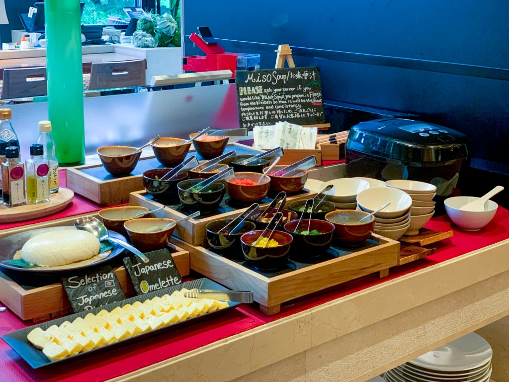 A miso soup station with small condiment dishes at the Brasserie breakfast buffet