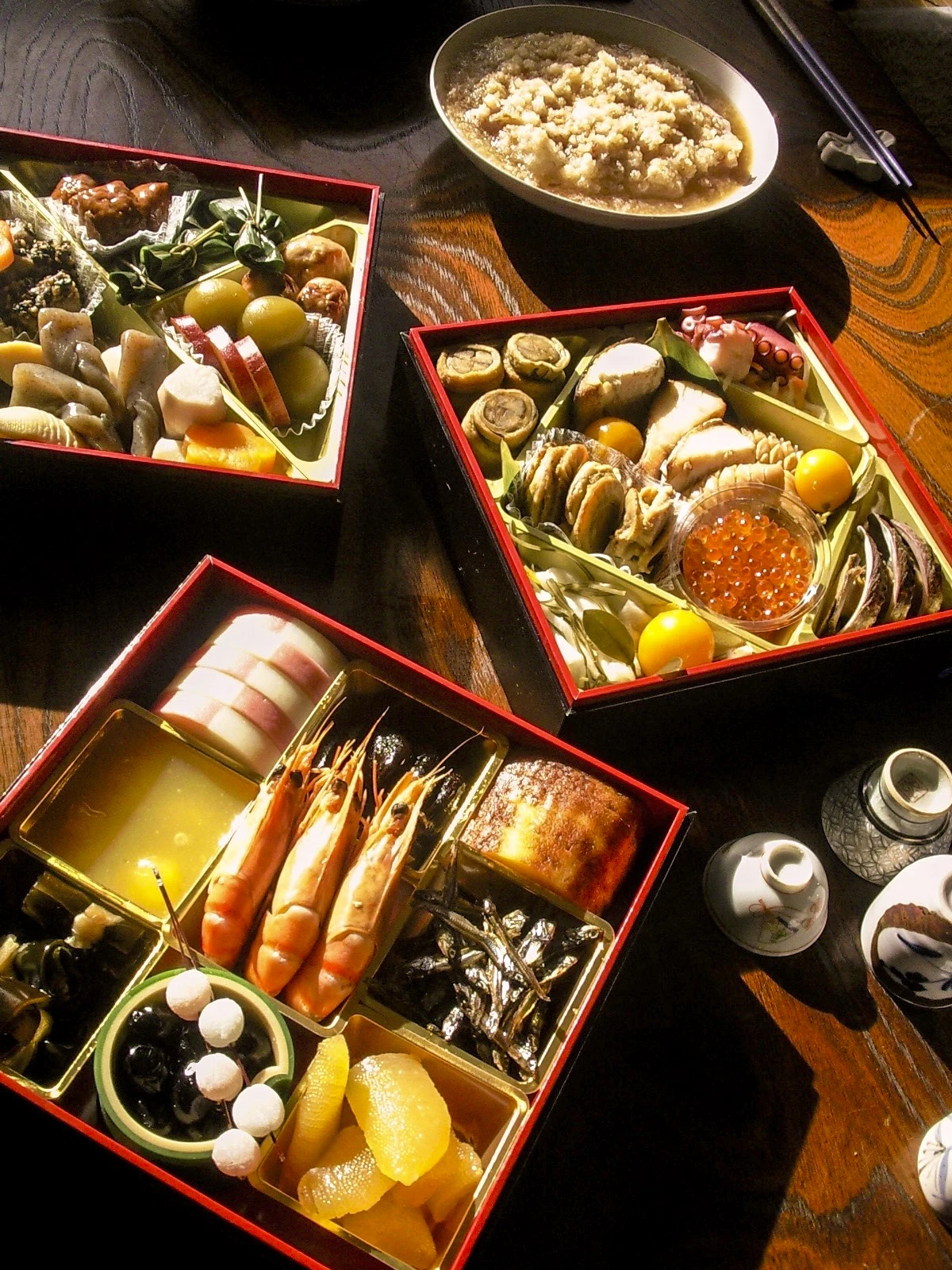 New Year's Table at a Japanese home, with bento-like boxed dish called Osechi, mochi (rice cakes) and 'sakazuki's (tiny ceramic cups for sake).