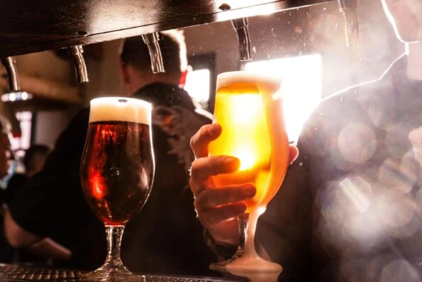 Close up of Stone Brewing beer being poured out of a tap.