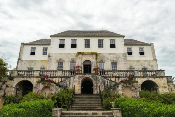 The brick and concrete exterior of Rose Hall in Jamaica on a cloudy day.