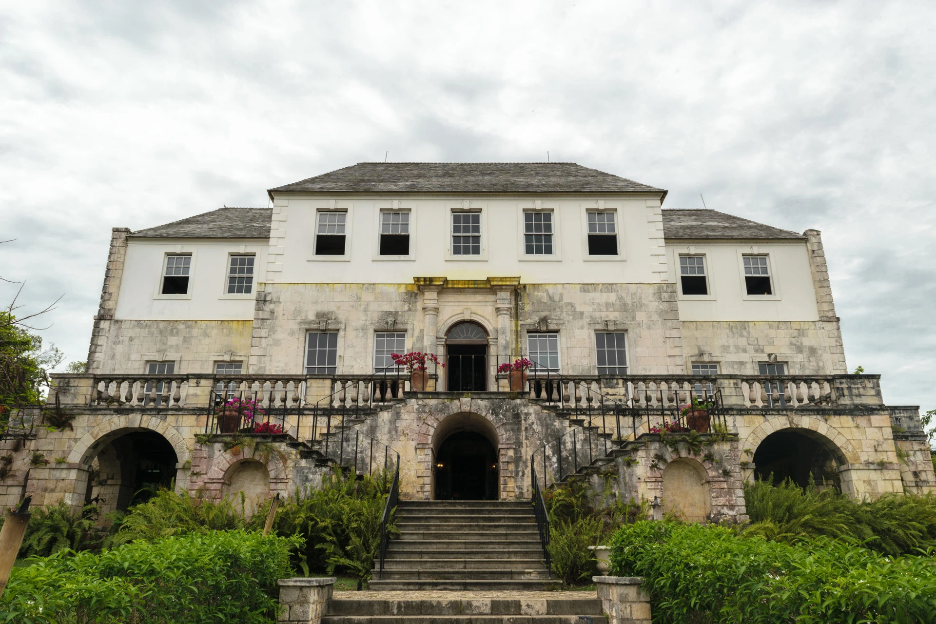 The brick and concrete exterior of Rose Hall in Jamaica on a cloudy day.