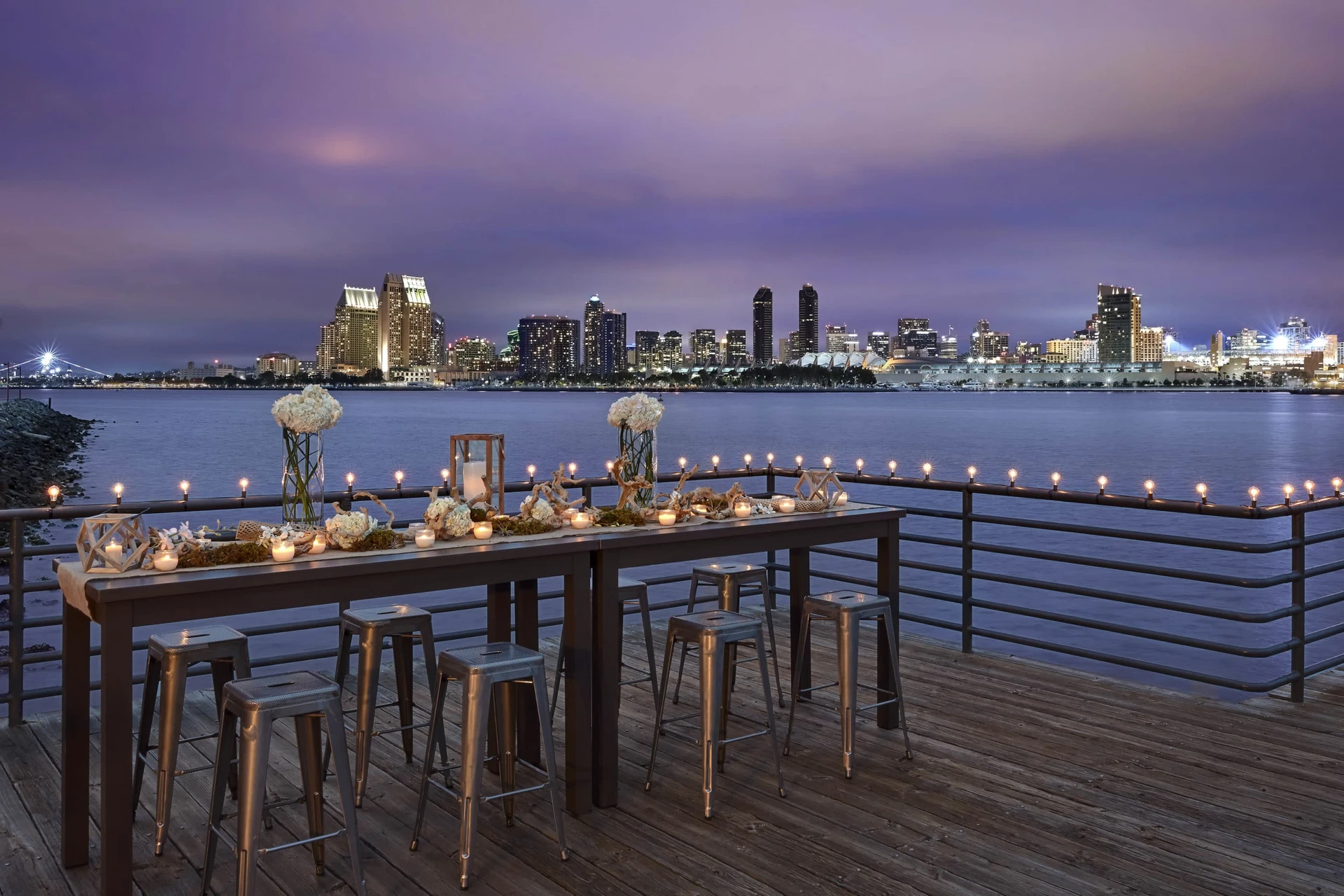 A decorated table on a patio overlooking downtown San Diego at dusk.