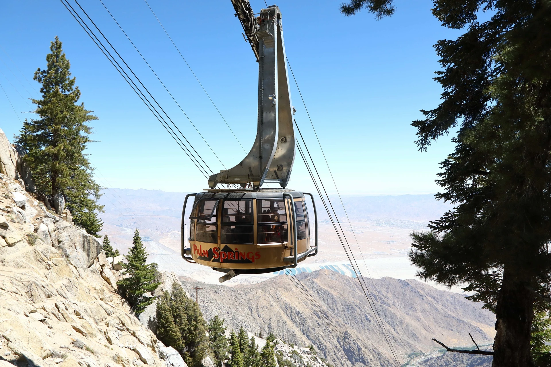 An enclosed tram moves guests downhill through the mountains.