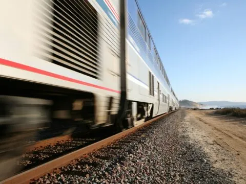 An Amtrak train passes by the Del Mar beach in San Diego at full speed