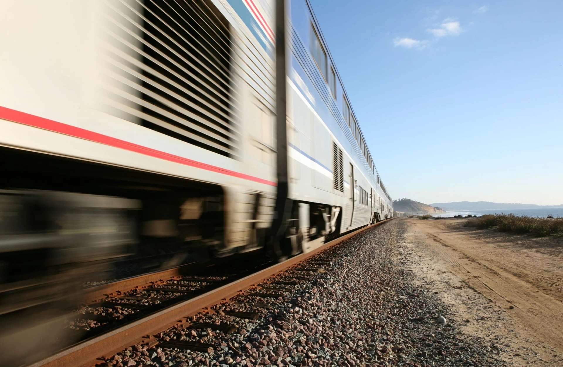 An Amtrak train passes by the Del Mar beach in San Diego at full speed
