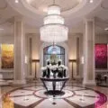 The lobby chandelier with flower vases on a table at Beverly Wilshire