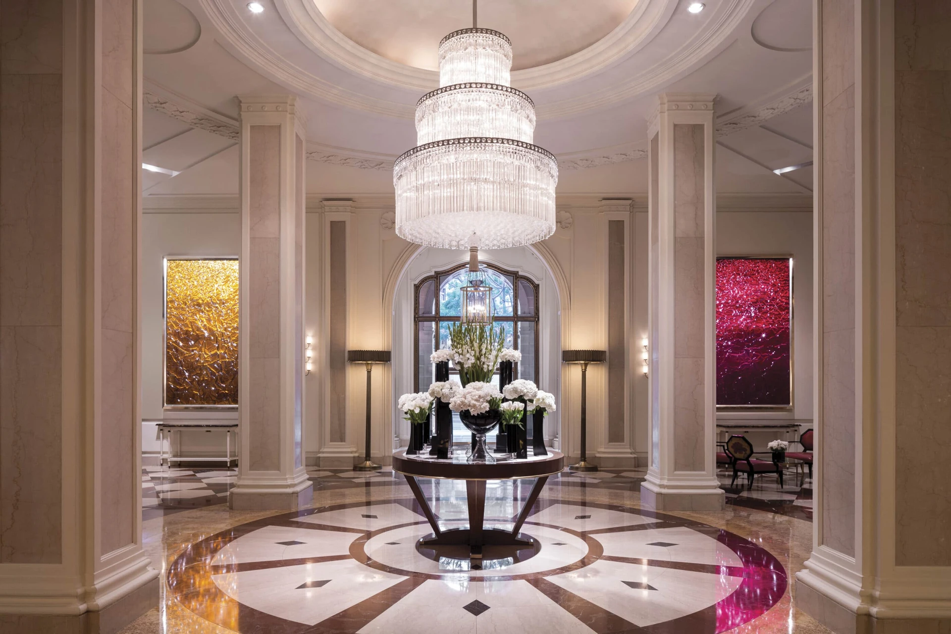 The lobby chandelier with flower vases on a table at Beverly Wilshire