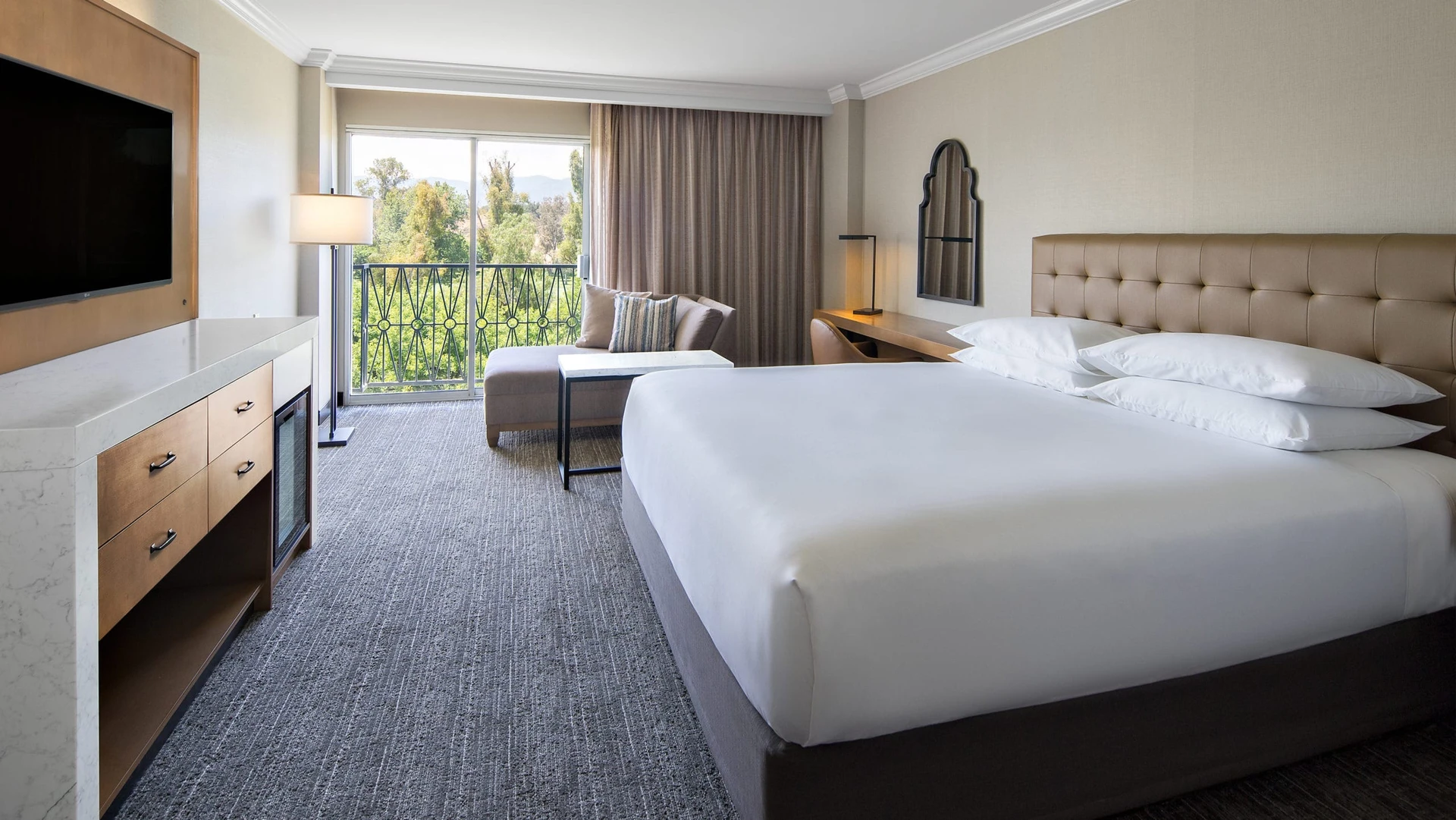 The contemporary interior with grey and neutral decor of a king room at Hyatt Regency Valencia.