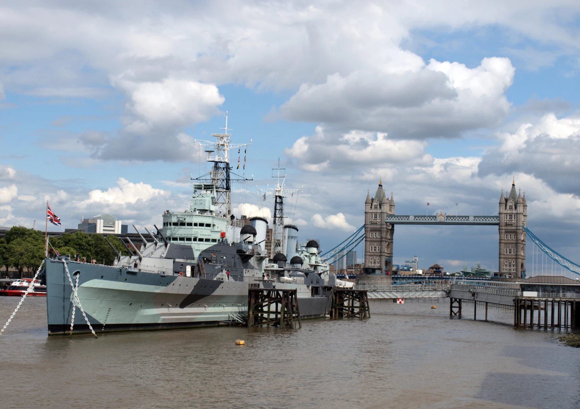 The HMS Belfast rests on the Thames River with the Tower Bridge in the background.