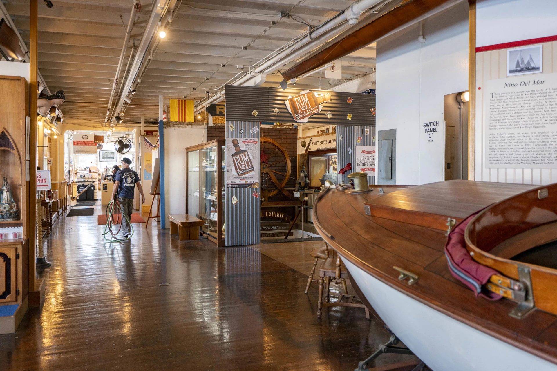 A staff member carries a rope through the exhibition gallery inside Steam Boat Berkeley at Maritime Museum of San Diego.