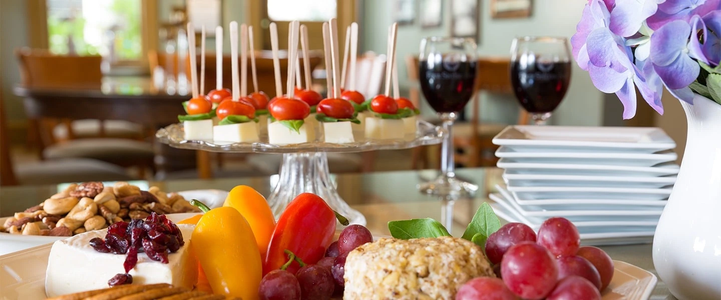 An appetizer spread next to full wine glasses at wine happy hour at 1906 Lodge Coronado