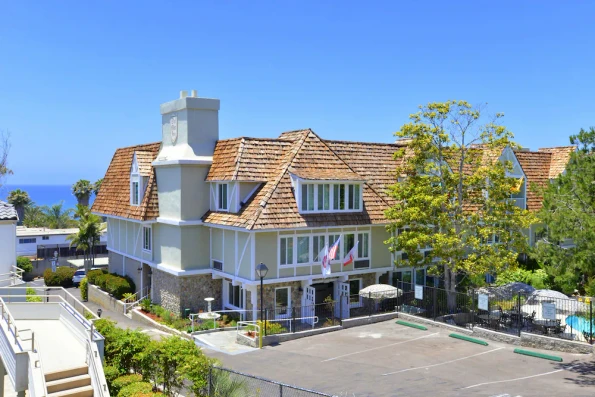 The parking lot entrance to Best Western Del Mar with the ocean in the background.