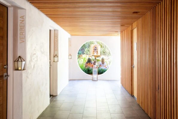 Two women site at the end of a hallway in a garden at Inn at Moonlight Beach