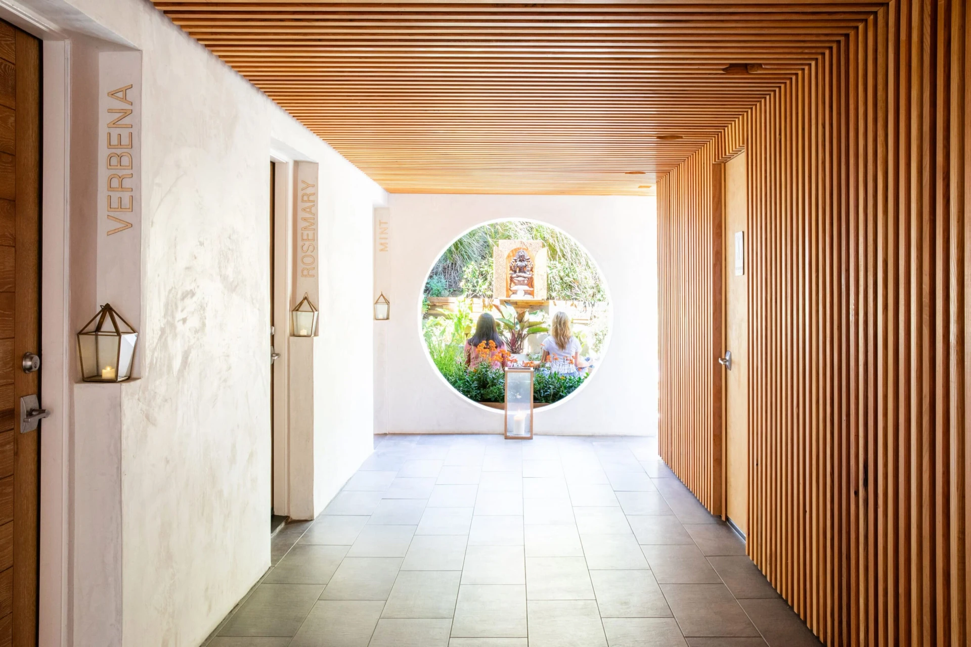 Two women site at the end of a hallway in a garden at Inn at Moonlight Beach
