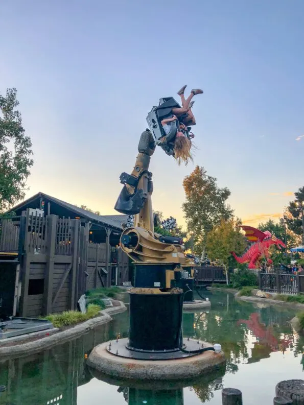 My daughter and her friend swing upside-down on Knights' Tournament.
