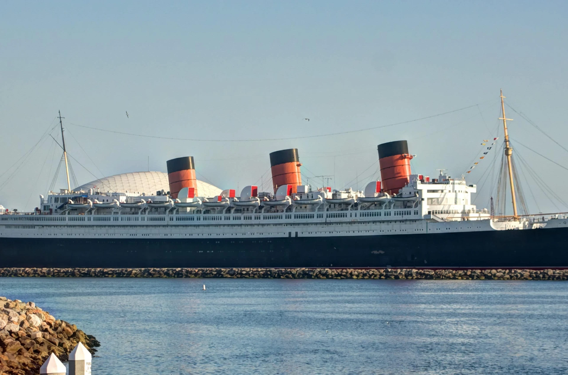 The Queen Mary docked in the water at Long Beach harbor.