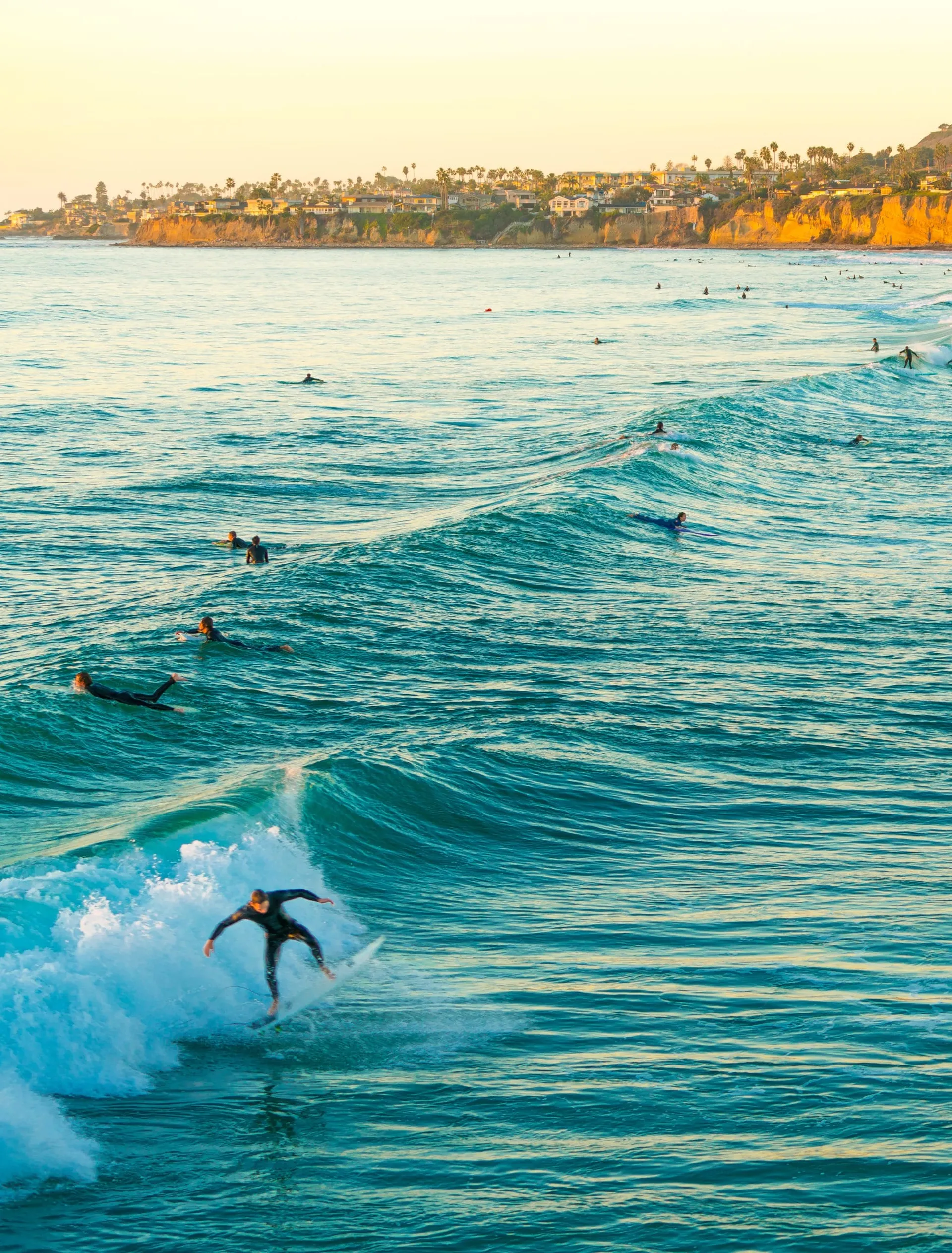 A surfer on a wave near sunset in Pacific Beach.