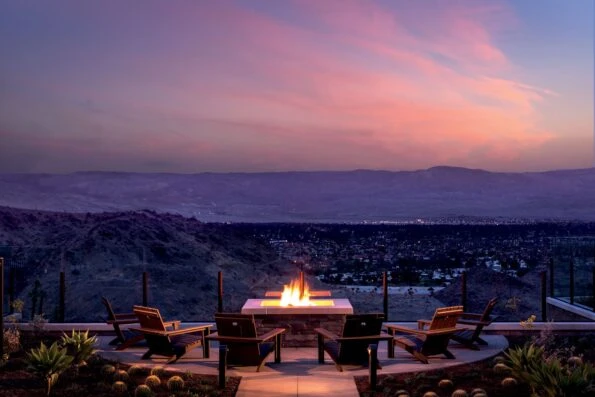 Lounge chairs around a fire pit at sunset at The Ritz Carlton Rancho Mirage