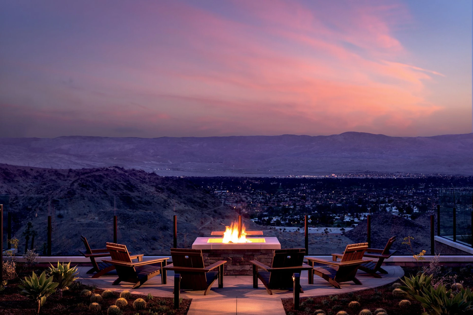 Lounge chairs around a fire pit at sunset at The Ritz Carlton Rancho Mirage