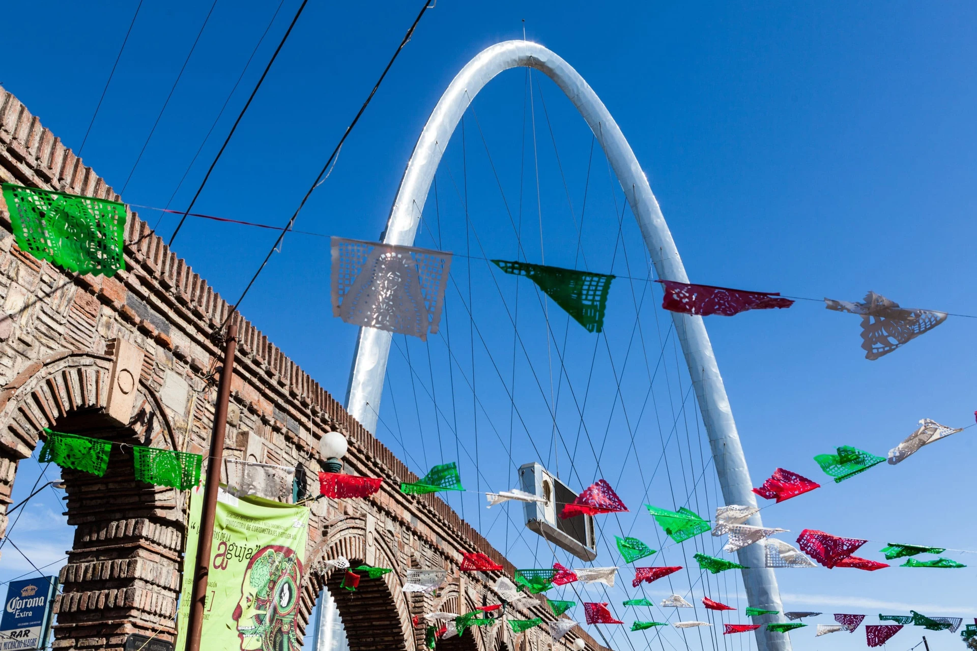 Red, white, and green flags fly near Millennial Arch in Tijuana, a popular day trip from San Diego.