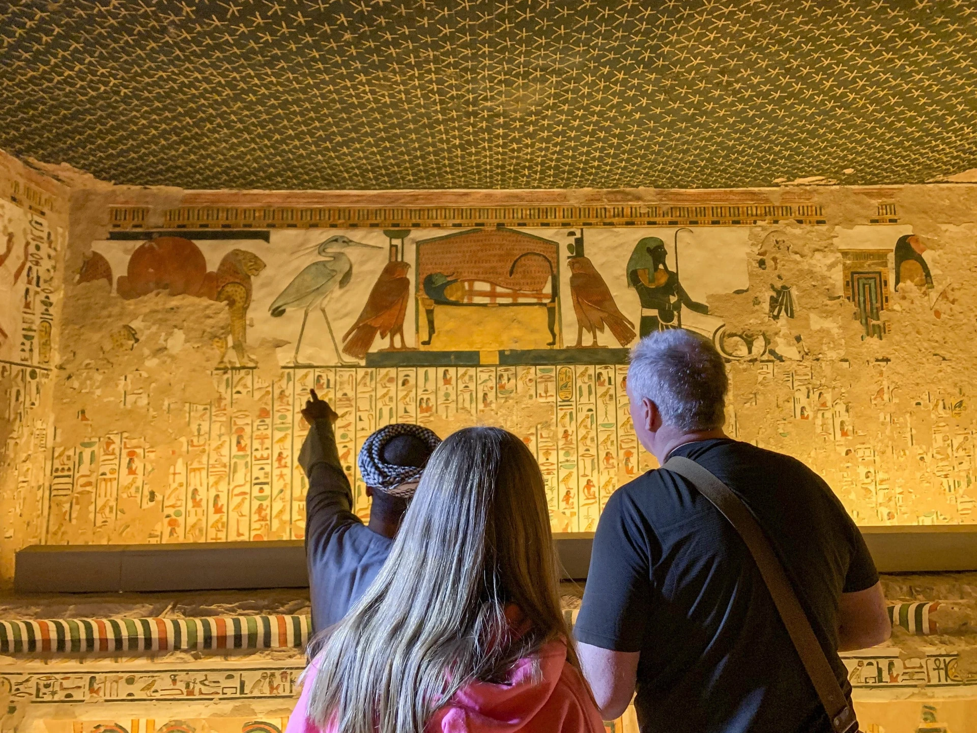 A worker shows two visitors around the tomb of Nefertari in Valley of the Queens.