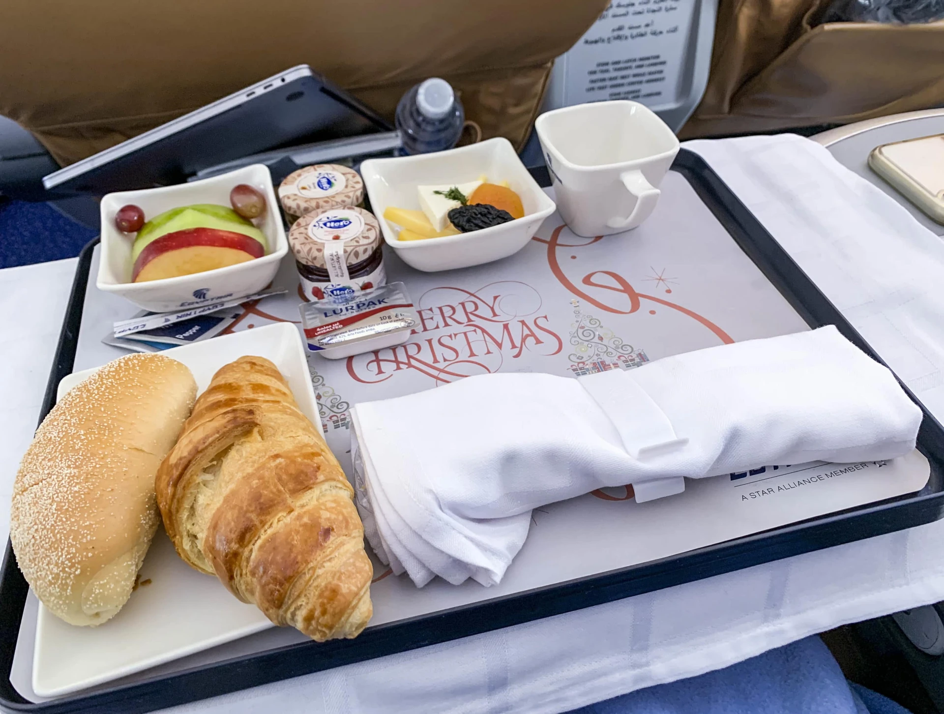 First course breakfast on EgyptAir business class with fruit, cheese, croissant, bread, on a tray.