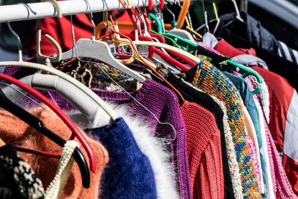 Vintage sweaters on a rack at a flea market.