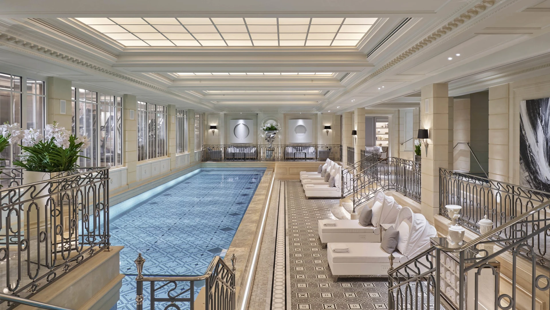 Plush lounge chairs surround the indoor spa lap pool at Four Seasons Paris.