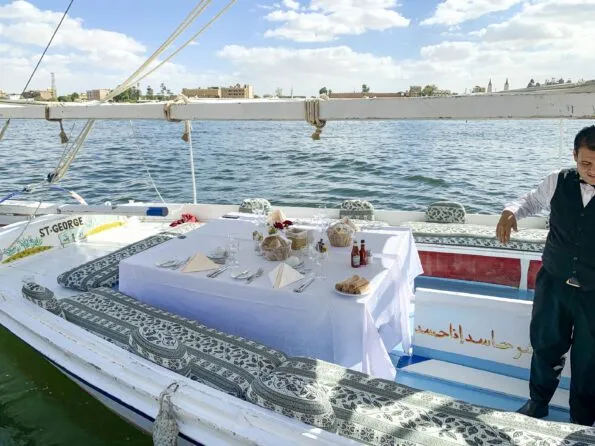 A set table with white tablecloth onboard our felucca.