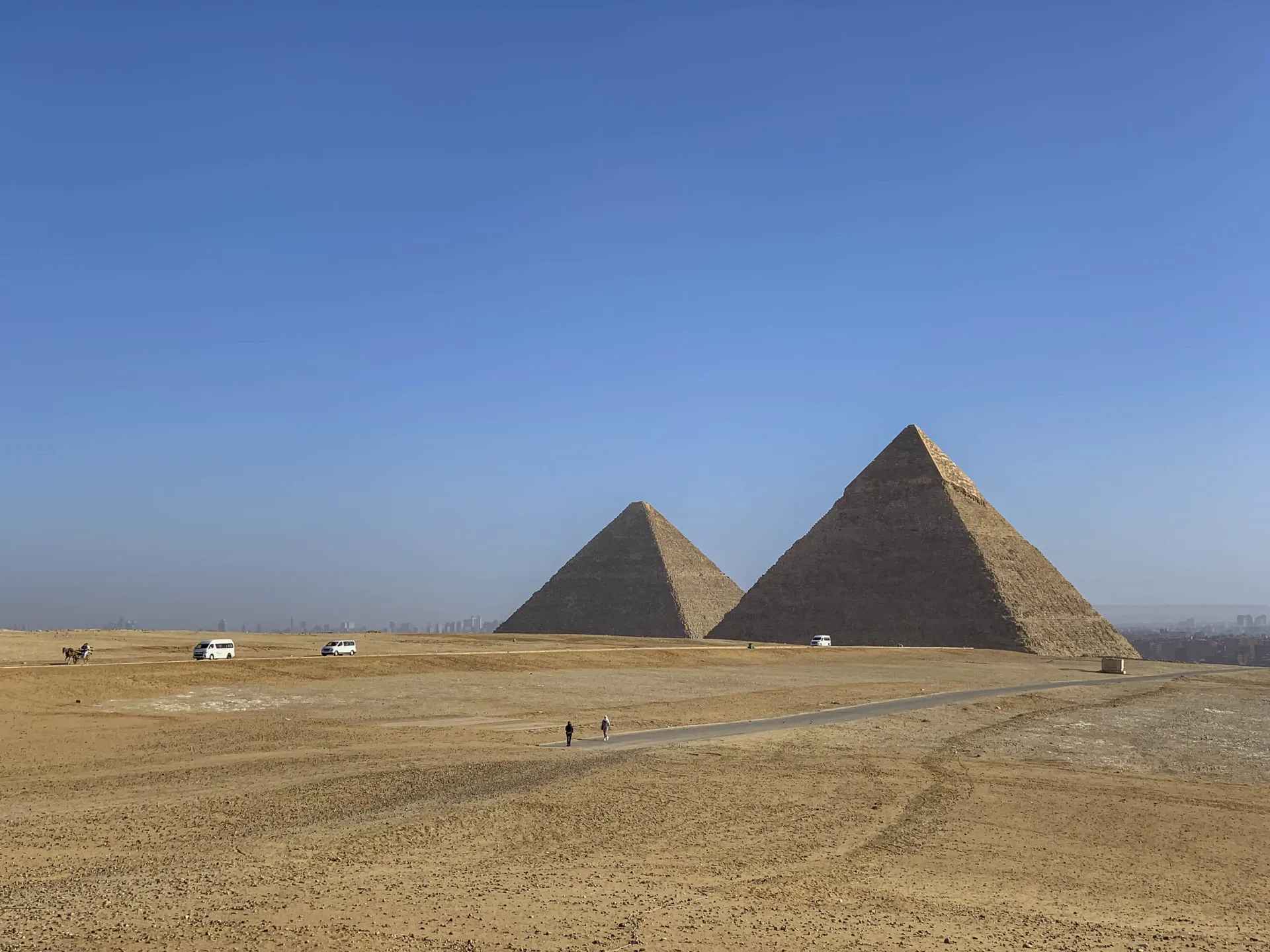 The pyramids of Giza surrounded by desert sand.