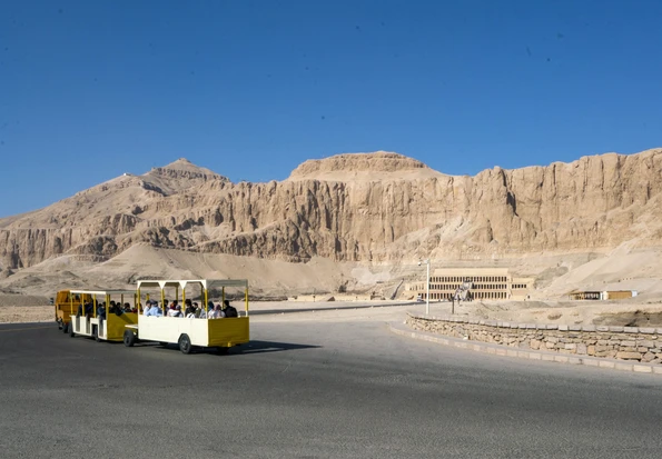 A yellow tram takes passengers from the parking lot to the entrance of Hepshetput Temple.