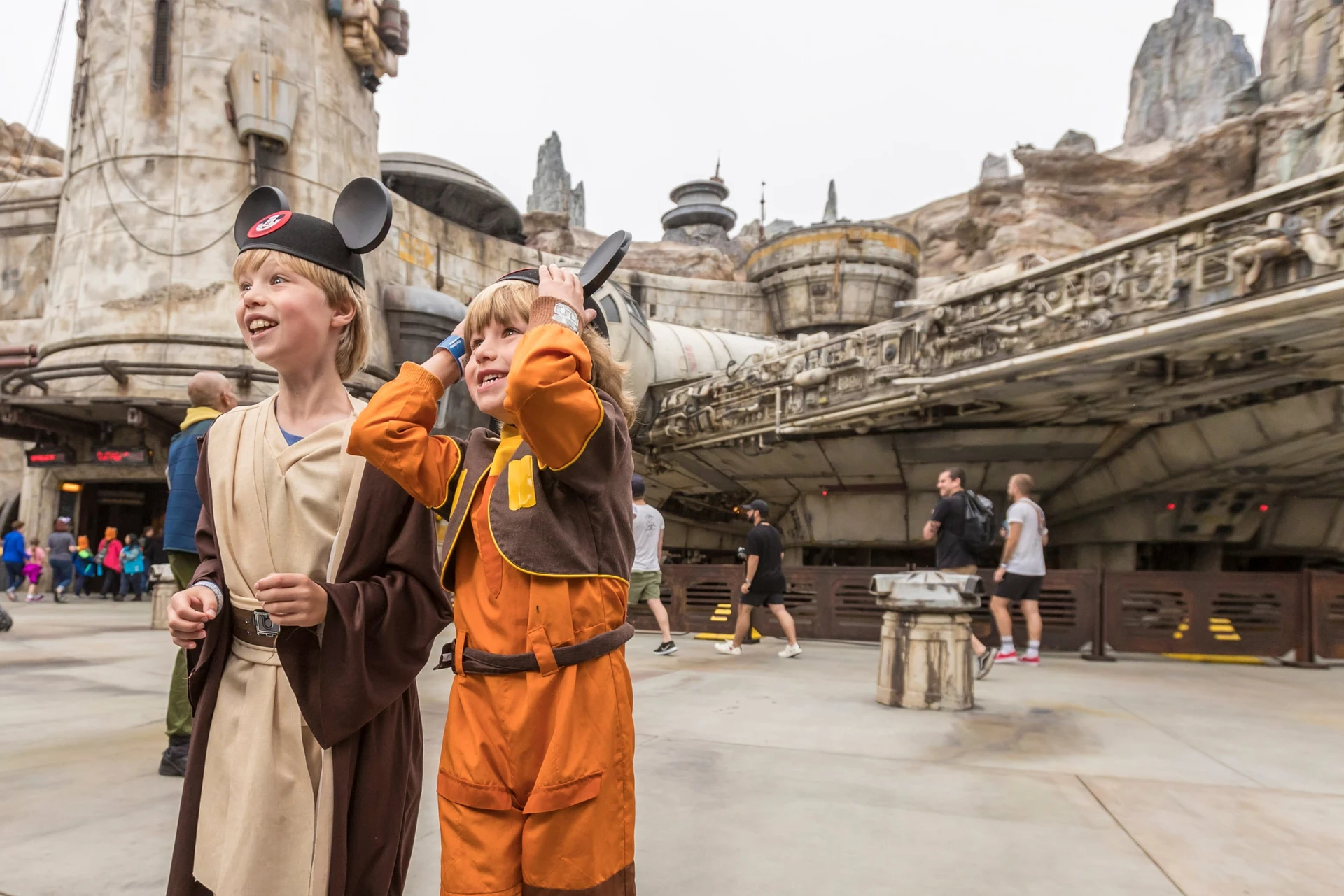 Two small boys in Star Wars costumes and wearing Mickey ears inside Star Wars: A Galaxy's Edge at Disneyland