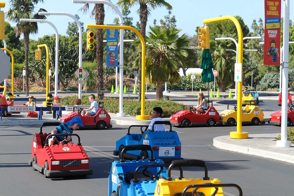 Kids drive around a track in LEGO cars at LEGOLAND California.